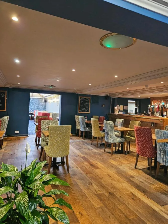 Restaurant with chairs and tables and a bar at The Queens Hotel & Victoria Cloisters Apartments in York