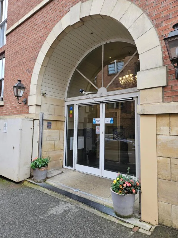 Entrance to the building with a glass door at The Queens Hotel & Victoria Cloisters Apartments in York